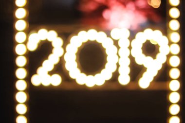 Mutlu yeni yıl bokeh tarzı arka plan tebrik kartı tasarımı. bulanık parlayan lambaları ve renkli 2019 şekil bulanıklaştırır