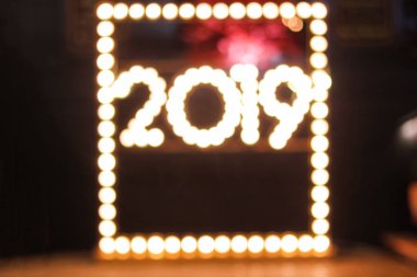 Mutlu yeni yıl bokeh tarzı arka plan tebrik kartı tasarımı. bulanık parlayan lambaları ve renkli 2019 şekil bulanıklaştırır. Yükleme