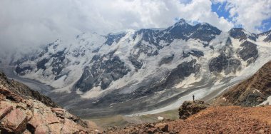 Panoramik dağ silsilesi ve büyük buzul Vadisi. Çerçeve içinde karşılaştırma için küçük adam. Bezengi duvar. Beyaz yüksek dağ rezerv