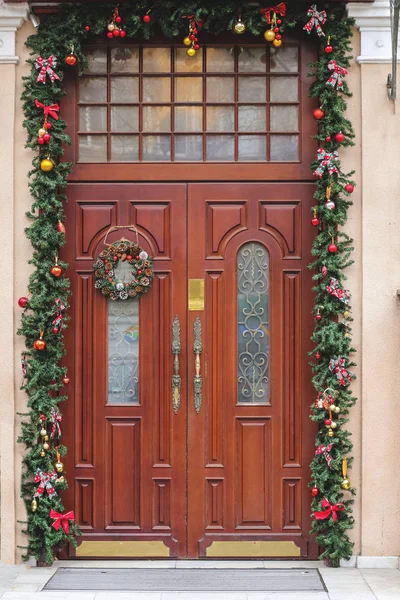 Front door with a Christmas wreath. Christmas decorations