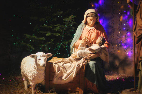 Christmas Manger scene with figures including Jesus, Mary, Joseph, sheep and magi. Soft focus