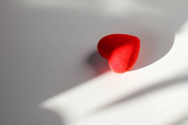 Güneş ışınları ve gölge beyaz bir arka plan üzerinde dekoratif kırmızı kalp. Senin metin için yer 