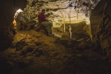 Bir mağaracı bir mağara bir fenerle araştırıyor. Odessa Catacombs, Ukrayna