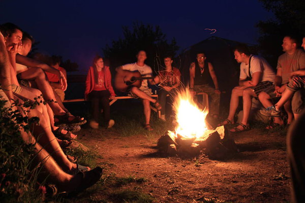 Mygiya / Ukraine - July 22 2018:People rest near a bonfire on the nigt. Outdoor activities with friends in nature.