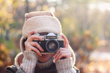Genç kadın sonbahar parkta fotoğraf çekmek. Kavramı kız fotoğrafçı. Yumuşak odak
