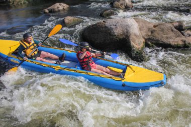 Mygiya / Ukrayna - 22 Temmuz 2018: mutlu genç kaç hayat yelekler içinde gülümseyen bir kayık yelken. Güney Bug Nehri rafting