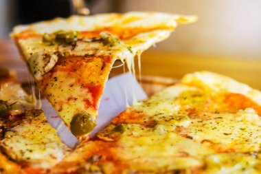 Yakın çekim. Vejetaryen pizza mantar, peynir ve zeytin, kesme ile karanlık bir arka plan üzerinde