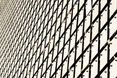 Binanın kinetik cephesi. Fırçalanmış paslanmaz çelikten metal plakalar serbestçe asılı ve rüzgarda savruluyor.