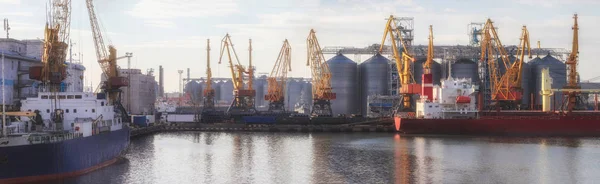 A carregar cereais para o navio no porto. Vista panorâmica do navio, guindastes e outras infra-estruturas do porto . — Fotografia de Stock