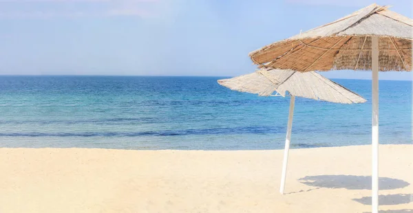Beach umbrellas and clean sand against the backdrop of the azure coast of the sea .Vacation and Tourism concept.