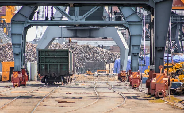 Deniz limanında yükleme vinçler altında demiryolu arabası. İş ve ulaşım. Kargo Terminali-deniz limanında demiryolu arabaları demiryolu taşımacılığı. Demiryolu yük vagonları. Liman demiryolu altyapısı.