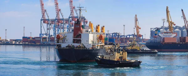 Буксир помогал грузовому судну маневрировать в порту Одессы, Украина. Обработка грузов и работа торгового порта . — стоковое фото