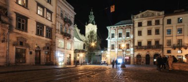 Geceleri Lviv panoraması. Avrupa ortaçağ kentinin gece sokak görünümü. Geceleri Lviv Market meydanı. Konsept - seyahat, simgesel yapılar, mimari anıt, dünya mirası. Uzun pozlama