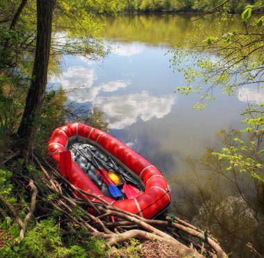 Kürekli kırmızı şişme tekne (gökyüzüne karşı bir nehir boyunca rafting için suya yansıyan. Yukarıdan görüntüle