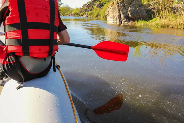 Widok z tyłu dłoni z czerwonym wiosło rafting na rzece, koncepcja sportów wodnych wiosną. Selektywna koncentracja — Zdjęcie stockowe
