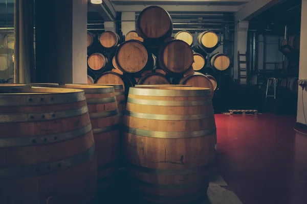 Barricas de madera con vino en bodega oscura. La producción moderna de vino con la observancia de tradiciones ancestrales . —  Fotos de Stock