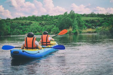 Genç çift nehirde beyaz su kanosunun keyfini çıkarıyor. Turistik yerlerde ekstrem ve eğlenceli bir spor. Pivdennyi Buh Nehri 'nde rafting. Nehir boyunca aktif macera çifti