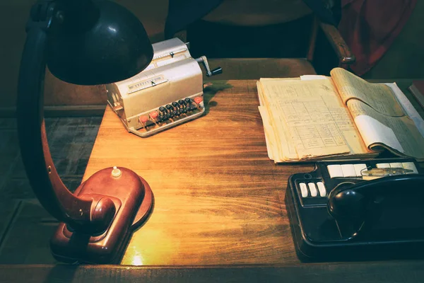 Oficina de trabajo de diseño: mesa antigua y teléfono analógico, lámpara en la mesa. Periodo de la Unión Soviética. Los ruidos y el grano grande - la estilización bajo la película —  Fotos de Stock