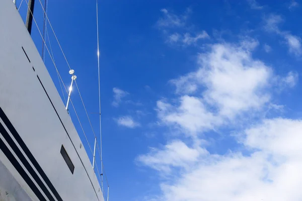 Часть белой яхты с мачтой на фоне голубого неба с облаками. Место для текста . — стоковое фото