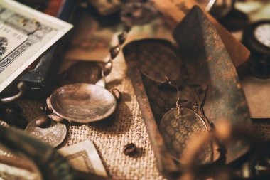 Masadaki farklı antika eşyalar: eski cep saatleri, banknotlar ve Rus İmparatorluğu sikkeleri, bir kasadaki gözlükler, gümüş eşyalar. Antika koleksiyonundan vintage arka plan. Seçili odak