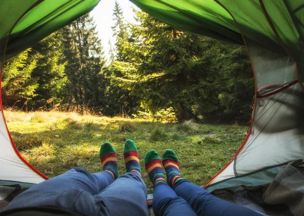 Blick von innen mit ein paar Beinen im Zelt - Reisereisekonzept mit jungen Leuten, die Abenteuer erleben. Konzept über Reisende, Natur, Camping und Lifestyle — Stockfoto