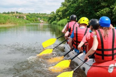 Rafting takımı, yaz ekstrem su sporları. Rafting teknesinde bir grup insan, nehirde güzel bir adrenalin gezisi. Arka plan.