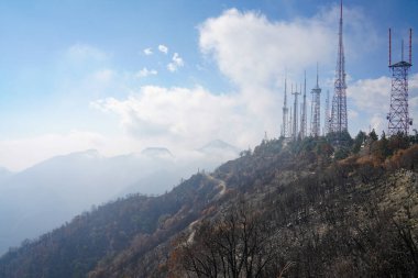Güzel bir günde, yaz mevsiminde sislerin arasında dağların arka planında yüksek bir kule.