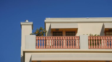 Mavi gökyüzü olan apartmanın balkonunda.