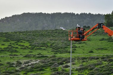 Asansör kova onarım sokak ışık direğe işçi. Sokak lambaları modernleştirme. Teknisyen hava aygıt insanlar üzerinde bir sokak lambası lambayı değiştirmek.