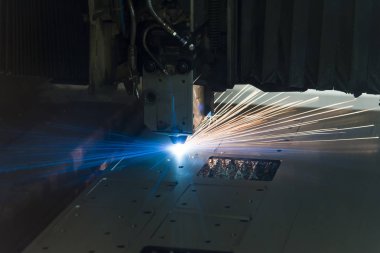 Endüstriyel lazer, düz metal levha ve kıvılcımlar üreten üretim teknolojisini kesiyor.