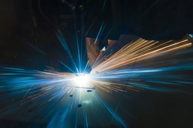 Endüstriyel lazer, düz metal levha ve kıvılcımlar üreten üretim teknolojisini kesiyor.