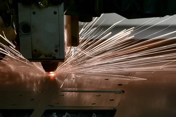 Endüstriyel lazer, düz metal levha ve kıvılcımlar üreten üretim teknolojisini kesiyor.