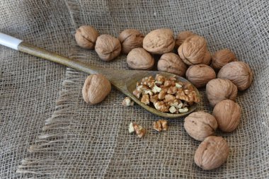 Çuval üzerinde, soyulmuş ceviz tahta bir kaşık üzerinde soyulmuş.