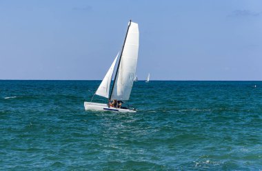 Akdeniz 'de mavi gökyüzü arka planında deniz yatında yarış yatı.