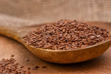 Keten tohumları yavaş çekimde döner. Tahta kaşıkta keten tohumu.