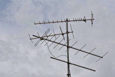 Gökyüzünde yağmur bulutları, yağmur bulutları ve eski TV antenleri hızla eser. Eski televizyon anteni.