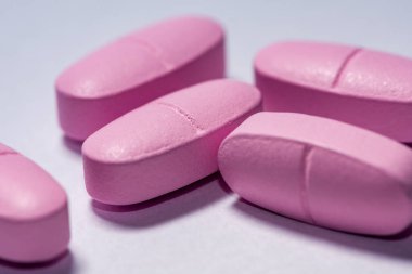 Üç pembe hapın yakın plan çekimi.