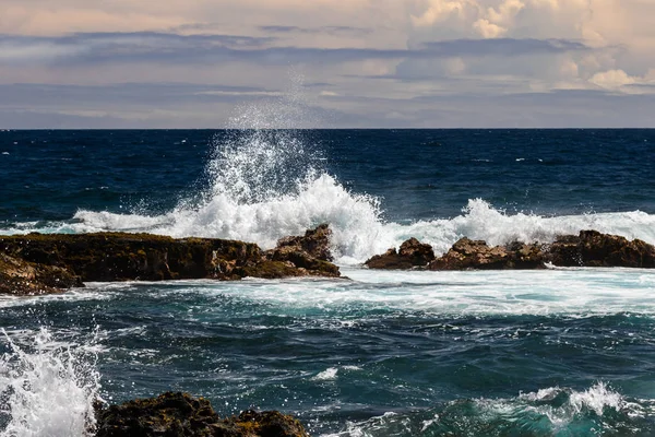 在夏威夷大岛的黑沙海滩 Punaluu 海浪在黑暗的火山岩上撞击 空气中出现白色喷雾 蓝色太平洋 天空和云在背景中 — 图库照片