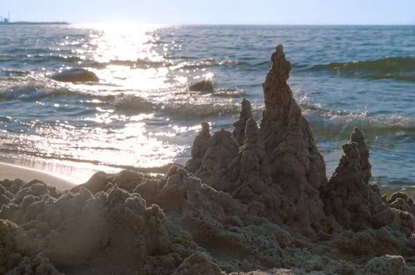 sand castle by the sea, sand castle in the rays of the setting sun