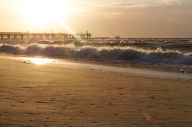 Rüzgar ve deniz, gün batımı ve deniz Baltık iskelede fırtınası