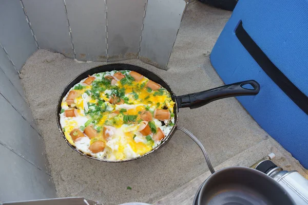 fried eggs cooked on a hike, tourist Breakfast fried eggs, fried eggs on a tourist burner