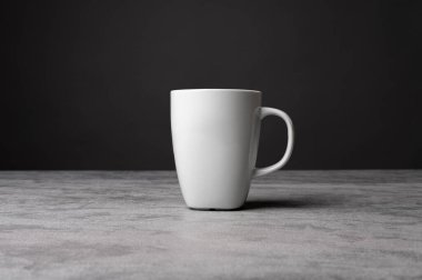  Gri bir taşın üzerine koyulmuş, koyu renkli, izole edilmiş ürün görüntüsü olan gri bir kahve fincanının minimalist stüdyo görüntüsü.