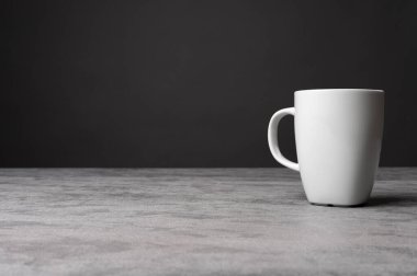  Gri bir taşın üzerine koyulmuş, koyu renkli, izole edilmiş ürün görüntüsü olan gri bir kahve fincanının minimalist stüdyo görüntüsü..