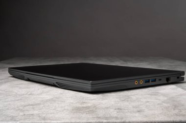 Gri arka planda modern siyah bir dizüstü bilgisayarın stüdyo fotoğrafı. Teknoloji, iş, bilişim, yenilik ve taşınabilir bilgisayar kavramları için uygundur..