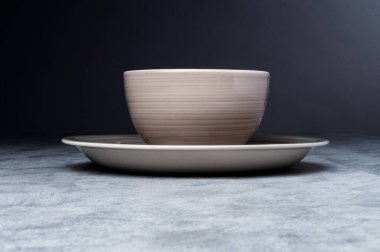 Minimalist seramik kâse koyu arka planda eşleşen tabakta.