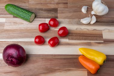 Çizgili ahşap kesme tahtasına yerleştirilmiş çeşitli taze sebzelerin tepeden tırnağa görüntüsü. Tarifler, yemek planlaması, yemek blogları ve fotokopi alanı olan yemek tasarımı için temiz mutfak hazırlık geçmişi.