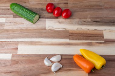 Çizgili ahşap kesme tahtasına yerleştirilmiş çeşitli taze sebzelerin tepeden tırnağa görüntüsü. Tarifler, yemek planlaması, yemek blogları ve fotokopi alanı olan yemek tasarımı için temiz mutfak hazırlık geçmişi.