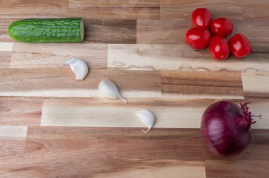 Çizgili ahşap kesme tahtasına yerleştirilmiş çeşitli taze sebzelerin tepeden tırnağa görüntüsü. Tarifler, yemek planlaması, yemek blogları ve fotokopi alanı olan yemek tasarımı için temiz mutfak hazırlık geçmişi.
