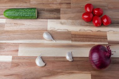 Çizgili ahşap kesme tahtasına yerleştirilmiş çeşitli taze sebzelerin tepeden tırnağa görüntüsü. Tarifler, yemek planlaması, yemek blogları ve fotokopi alanı olan yemek tasarımı için temiz mutfak hazırlık geçmişi.