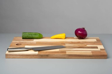 Çizgili ahşap kesme tahtasına yerleştirilmiş çeşitli taze sebzelerin tepeden tırnağa görüntüsü. Tarifler, yemek planlaması, yemek blogları ve fotokopi alanı olan yemek tasarımı için temiz mutfak hazırlık geçmişi.